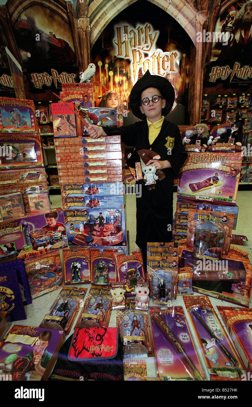 Harry Potter toys and games, October 2001 Boy dressed as a Wizard in Hogwarts robes surrounded by Harry Potter merchandise Stock Photo