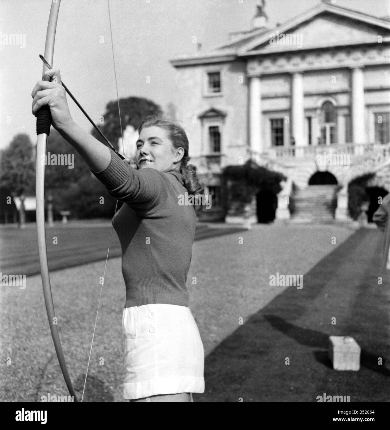 Taking part in the documentary film 'Archery' which is being made by Faro Films, London, is pretty Miss Sylvia Chapman, 18, from Kingsbury. Seen have filming in Richmond park. April 1953 D2093-001 Stock Photo