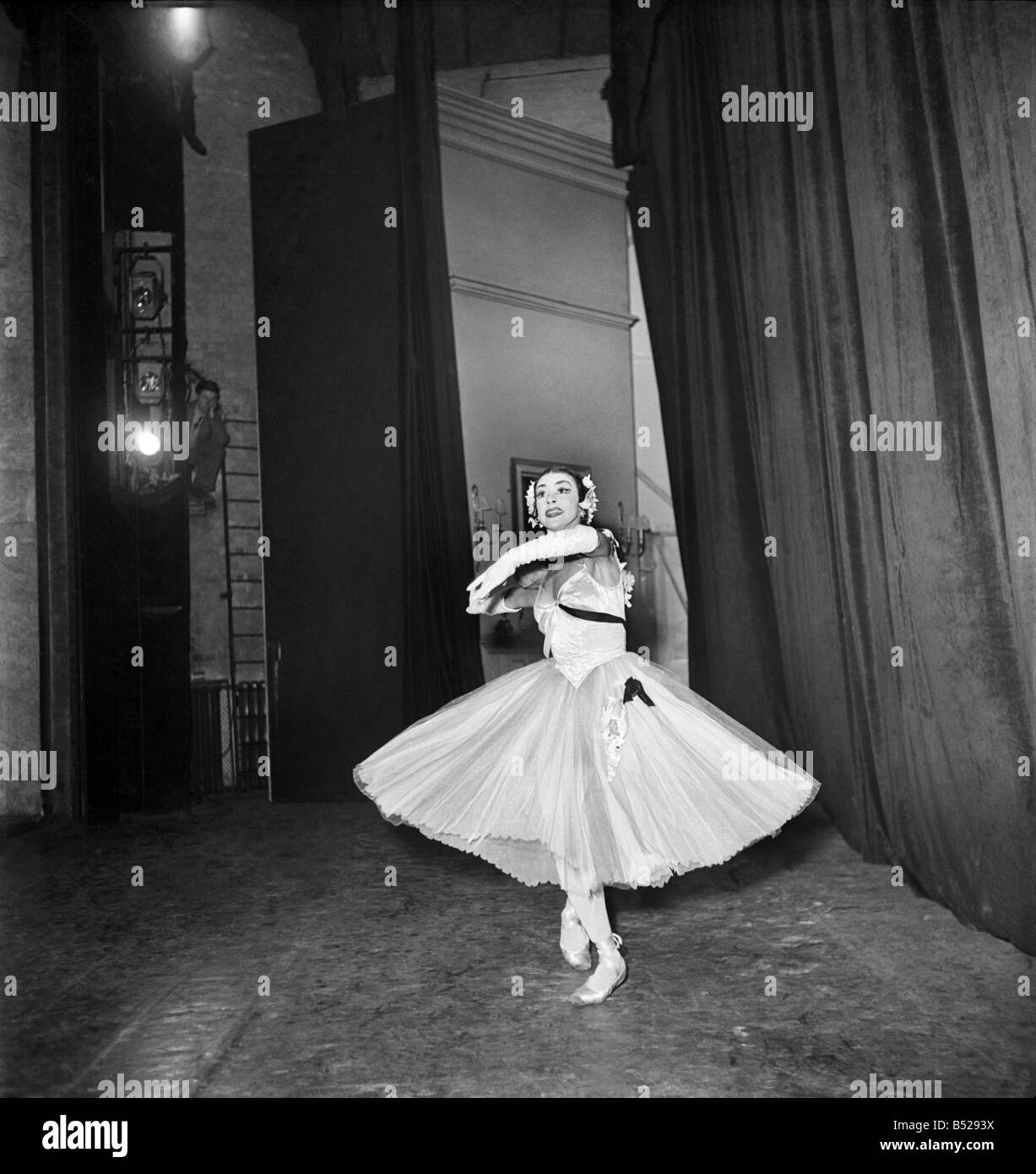 1950s BRUNETTE BALLERINA WEARING TUTU STANDING EN POINTE BEFORE STAGE  CURTAIN LOOKING AT CAMERA HANDS ON HIPS - d2445 HAR001 HARS JOY LIFESTYLE  FEMALES JOBS HEALTHINESS COPY SPACE FULL-LENGTH LADIES PERSONS ENTERTAINMENT