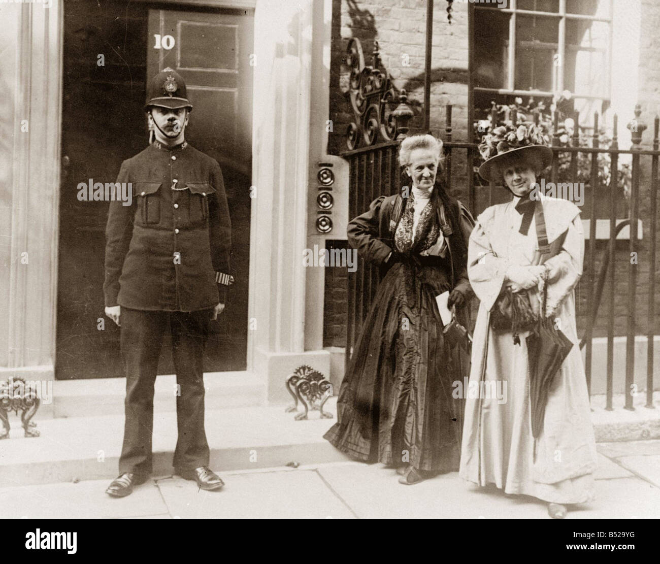Madame Despard centre August 1909 Pictured outside No10 Downing Street to see Prime Minister Mr Asquith also pictured is Mrs C Saunderson right Suffragettes 1900s Police Policeman Womens Rights Movement Stock Photo
