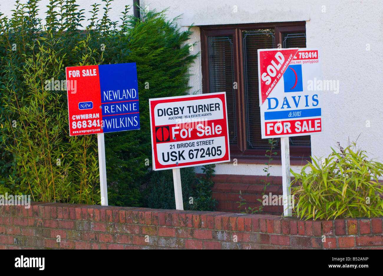 Estate agent for sale boards on semi detached house UK GB Stock Photo