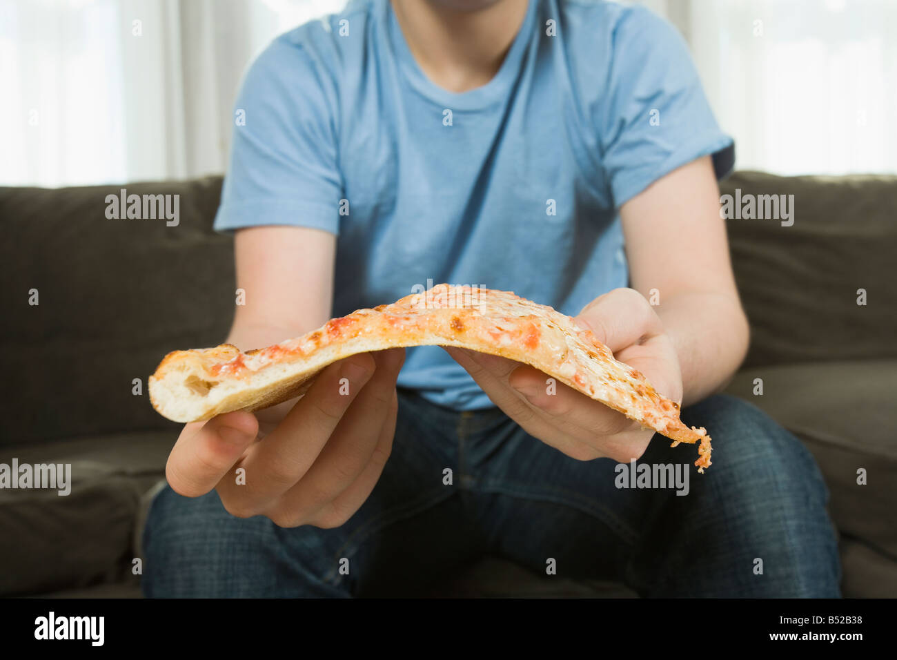 Teenage boy holding pizza Stock Photo - Alamy