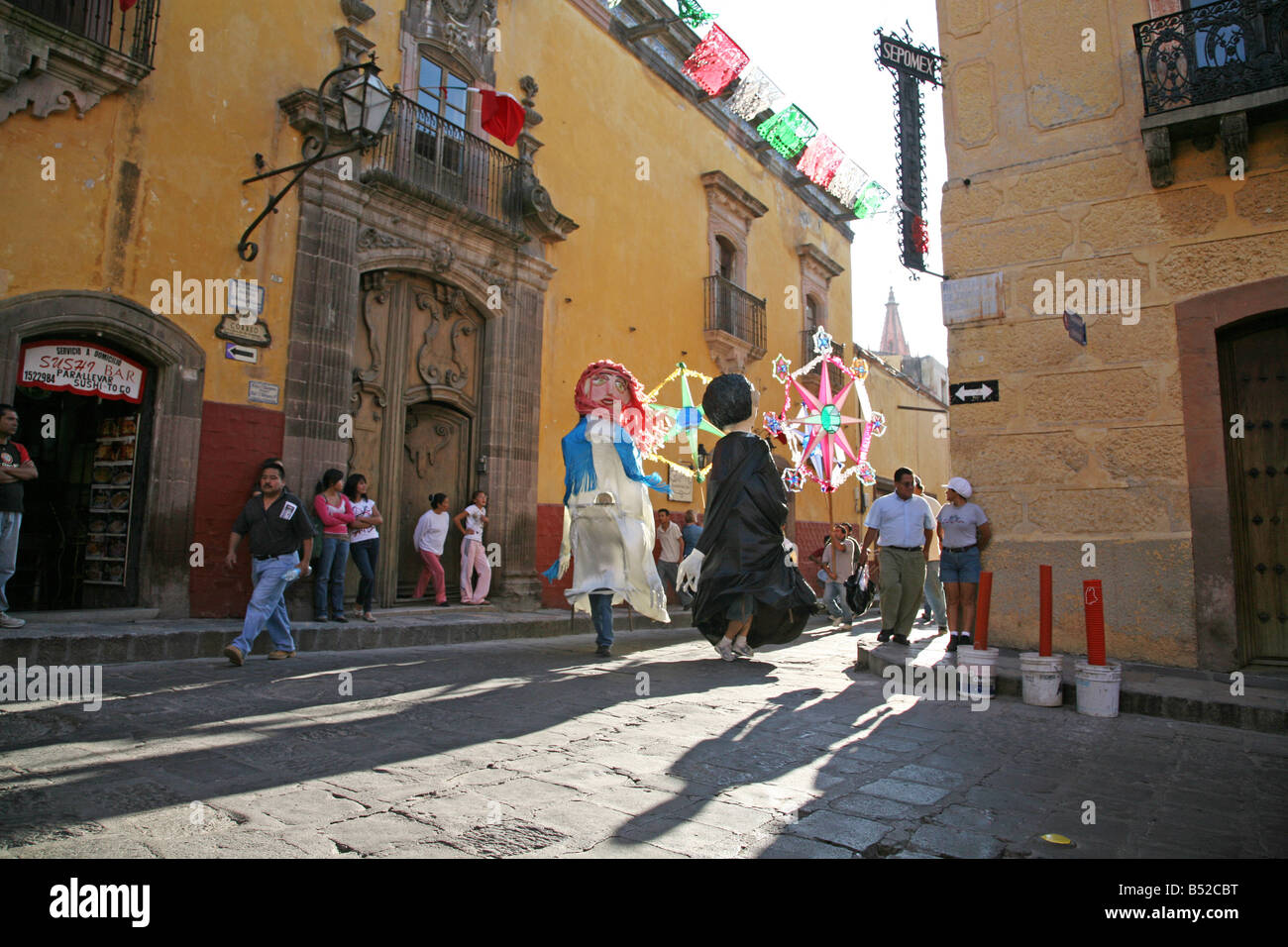 Street parade celebration in Mexico with larger than life size puppets. People watching a parade Stock Photo