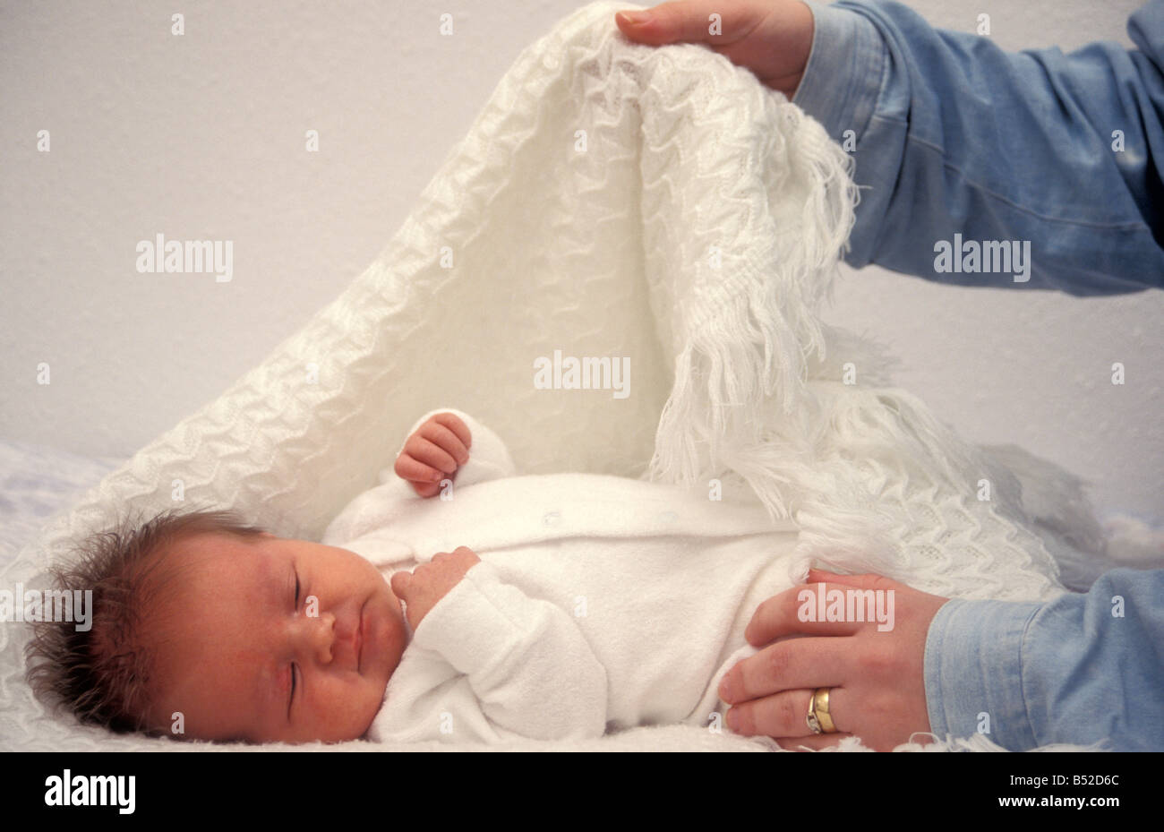 adults hands swaddling baby in blanket Stock Photo Alamy