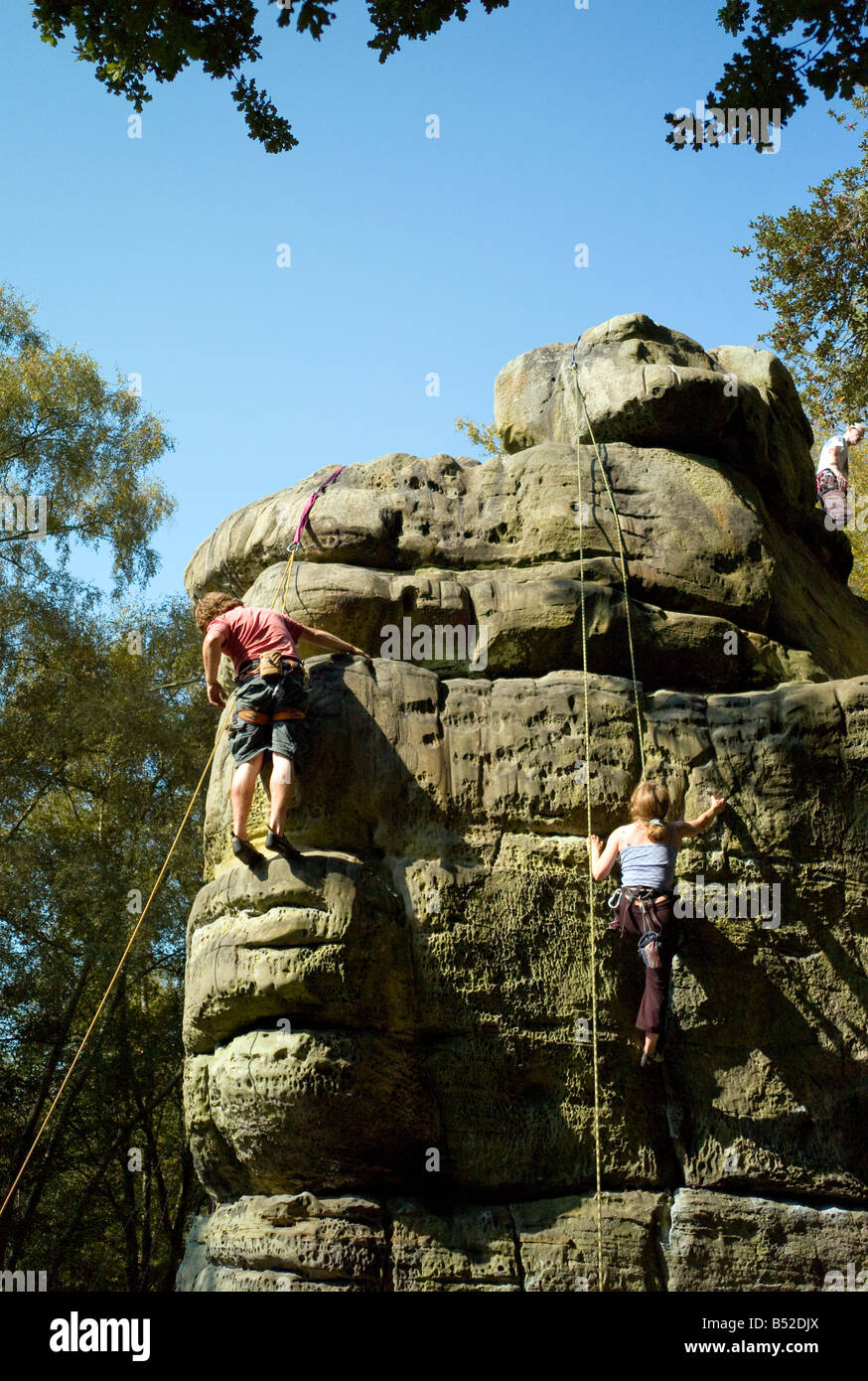 Two young climbers on top ropes climbing on sandstone crag, Harrisons