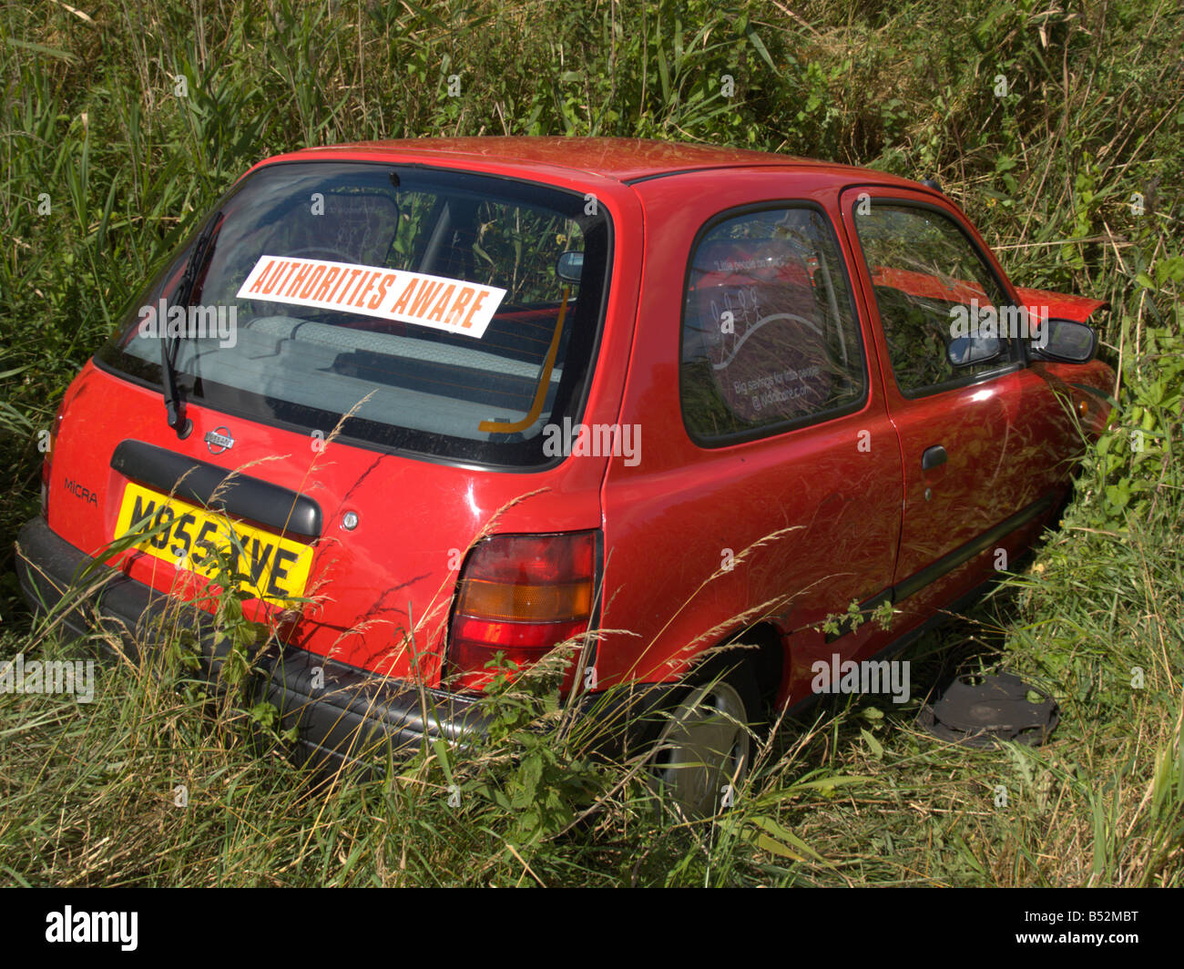 road traffic car accident rta skidded off road red car field ditch the fens england uk europe Stock Photo