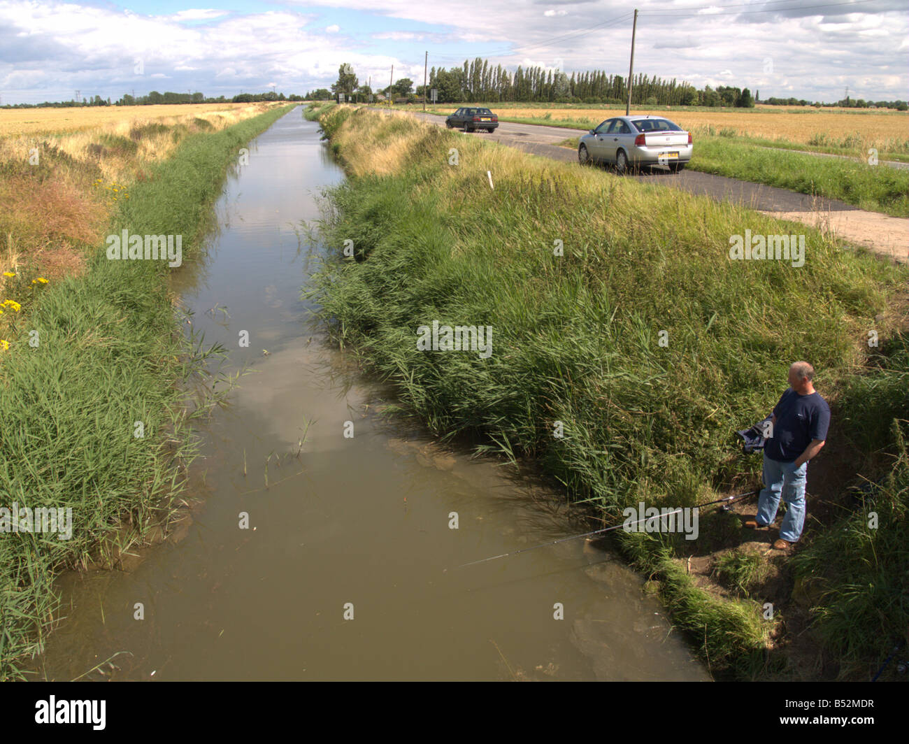 drainage channel river fisherman fishing fly bank ravensbank lincolnshire england uk europe the fens Stock Photo