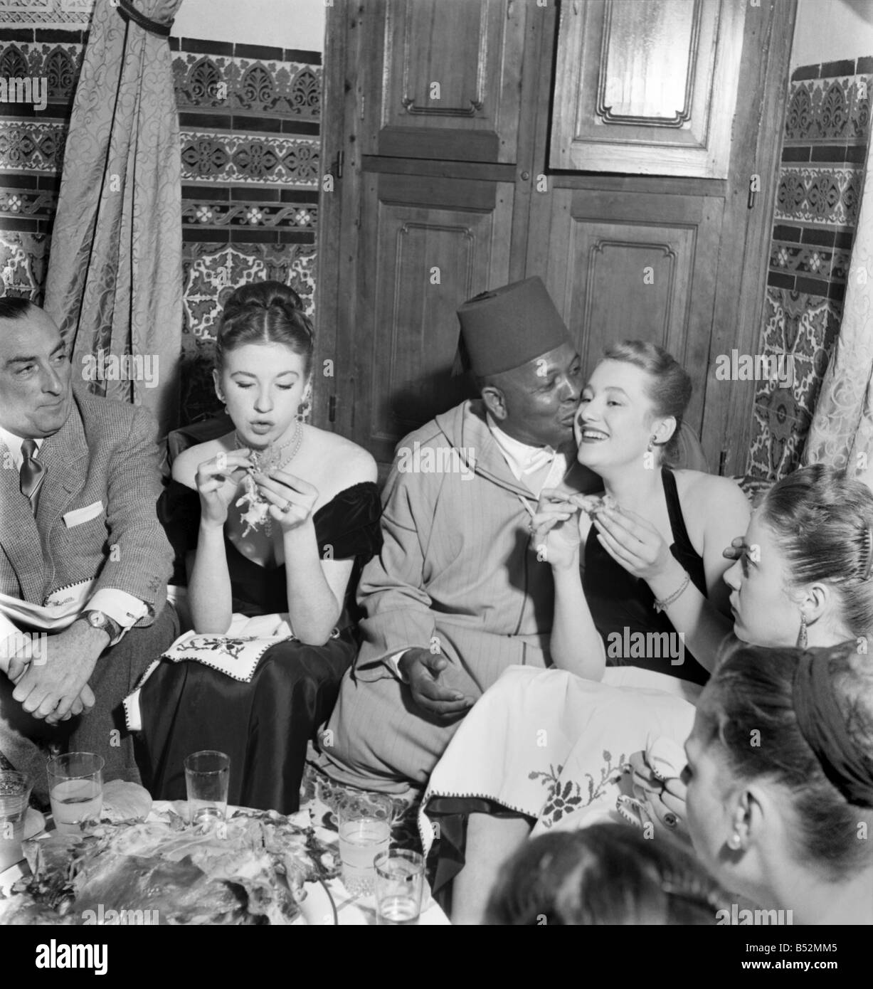 French actresses who have travelled over to Marrakech, Morocco meeting one of the locals on a night out in the town.;Dec. 1952 C Stock Photo