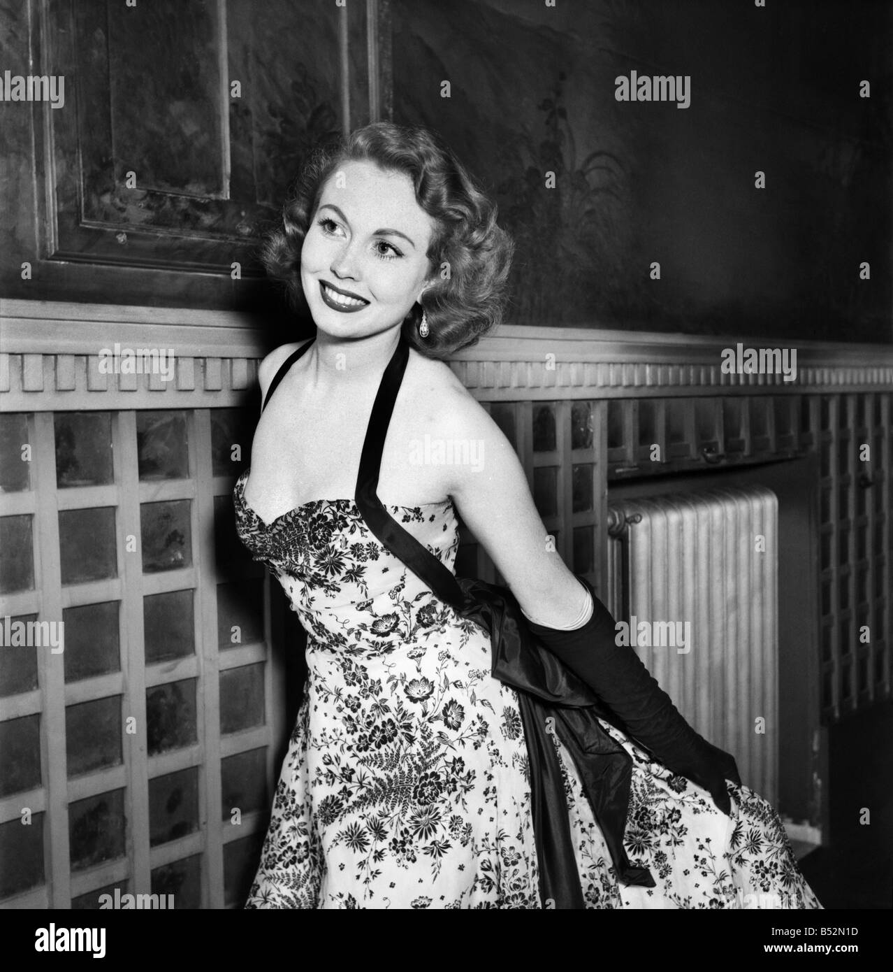 Clothing Fashion 1953. Miss Hazel Court arrives wearing a black velvet floral design on lemon organdie dress. June 1953 Stock Photo