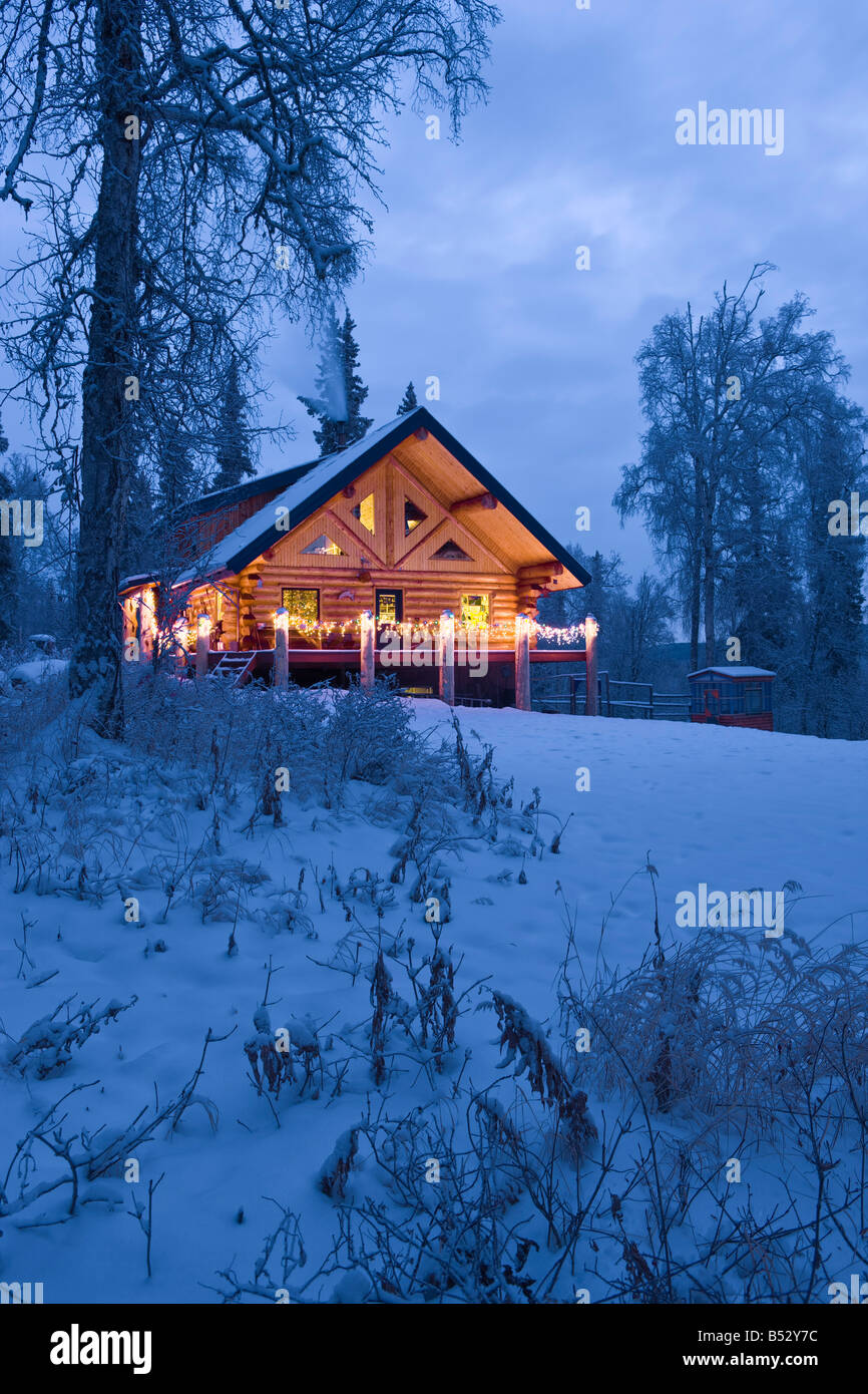 Log Cabin in the woods decorated with Christmas lights at twilight near ...