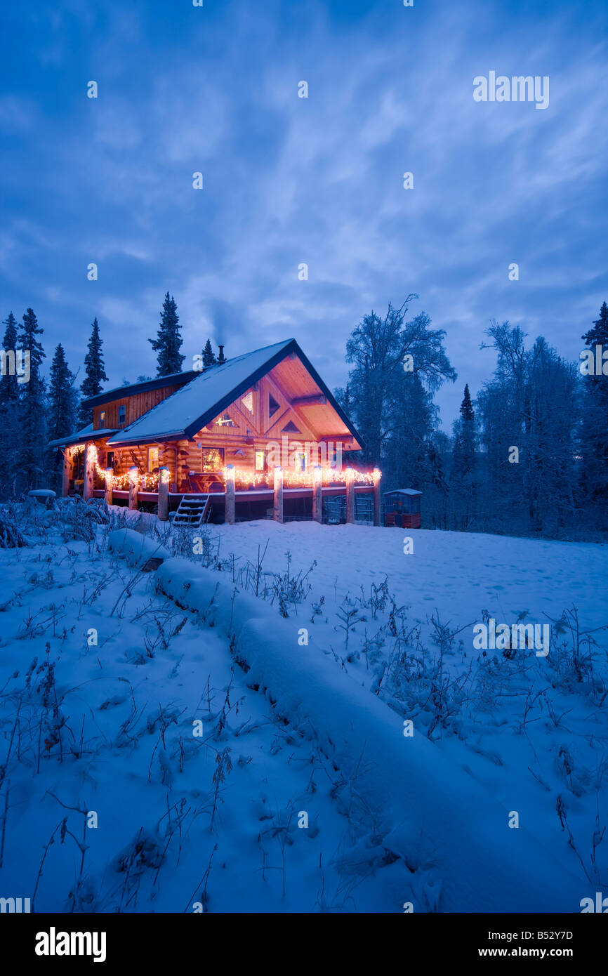 Log Cabin In The Woods Decorated With Christmas Lights At Twilight