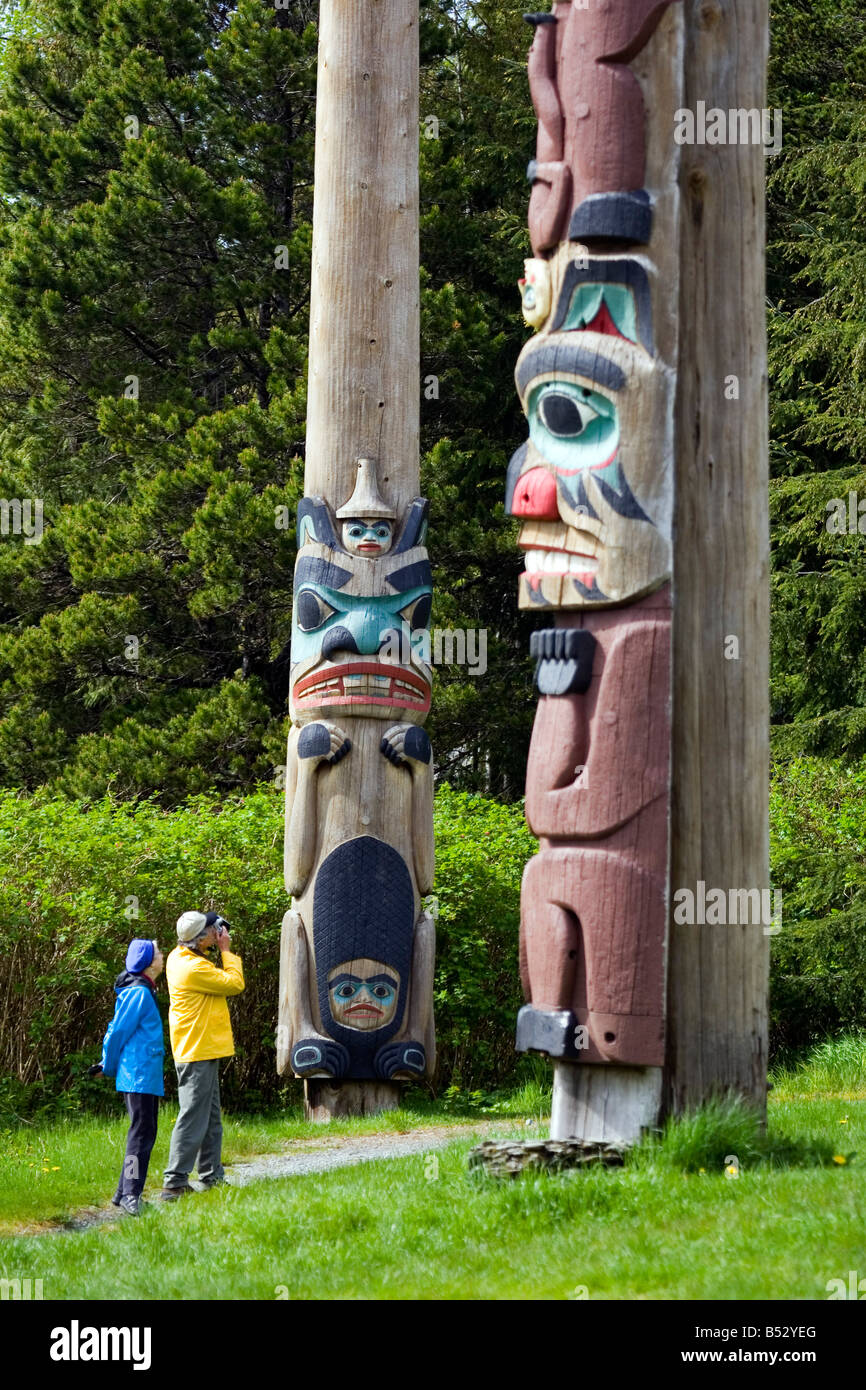 Tourist Photographing Totem Pole At Saxman Totem Park Near Ketchikan