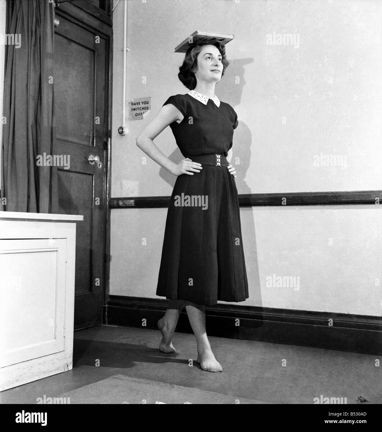 A woman balancing a book on her head during deportment classes. October
