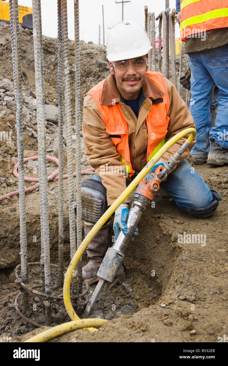 Hispanic construction worker holding equipment Stock Photo