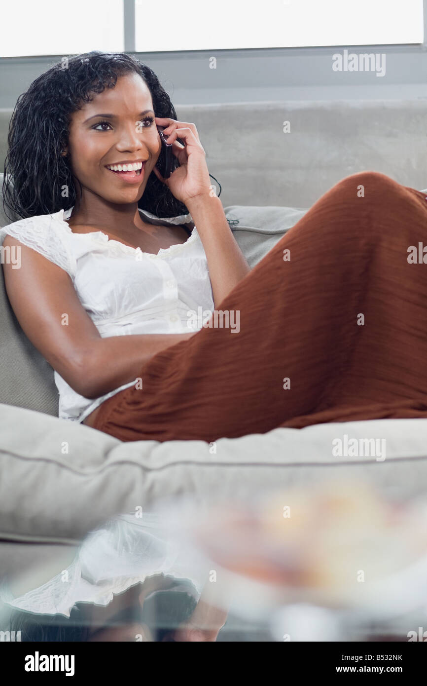 Panamanian woman on cell phone in living room Stock Photo