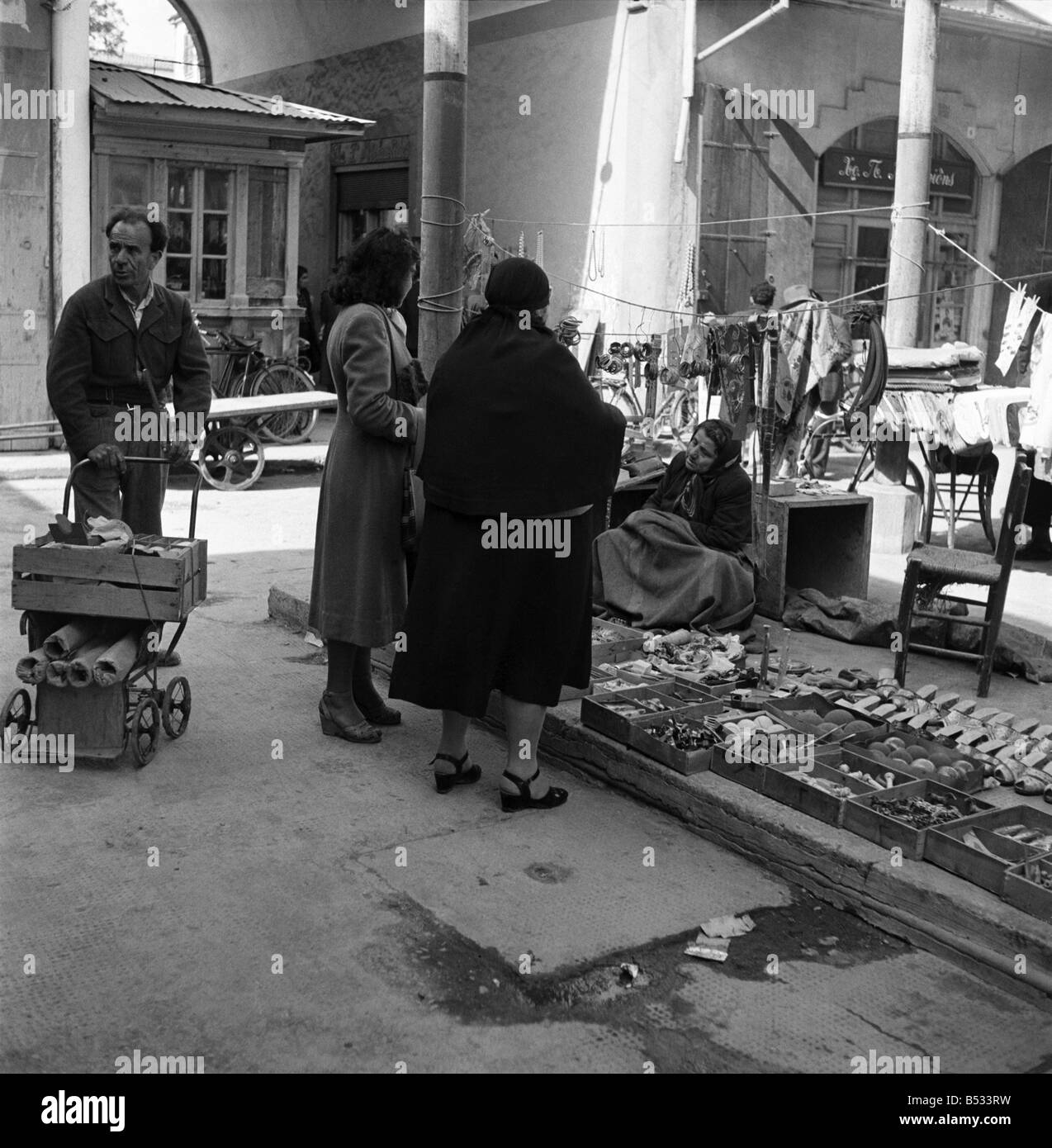 Traders at the Ladies Bazaar which opens every Friday in Nicosia, Cyprus,. The market sells items as diverse as lace, silk, embroideries, fruit and food. November 1952 C1105-003 Stock Photo