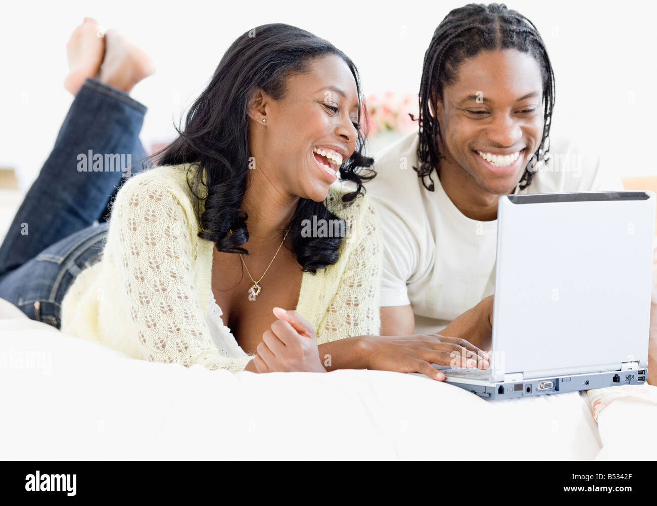 African couple on laptop in bed Stock Photo - Alamy