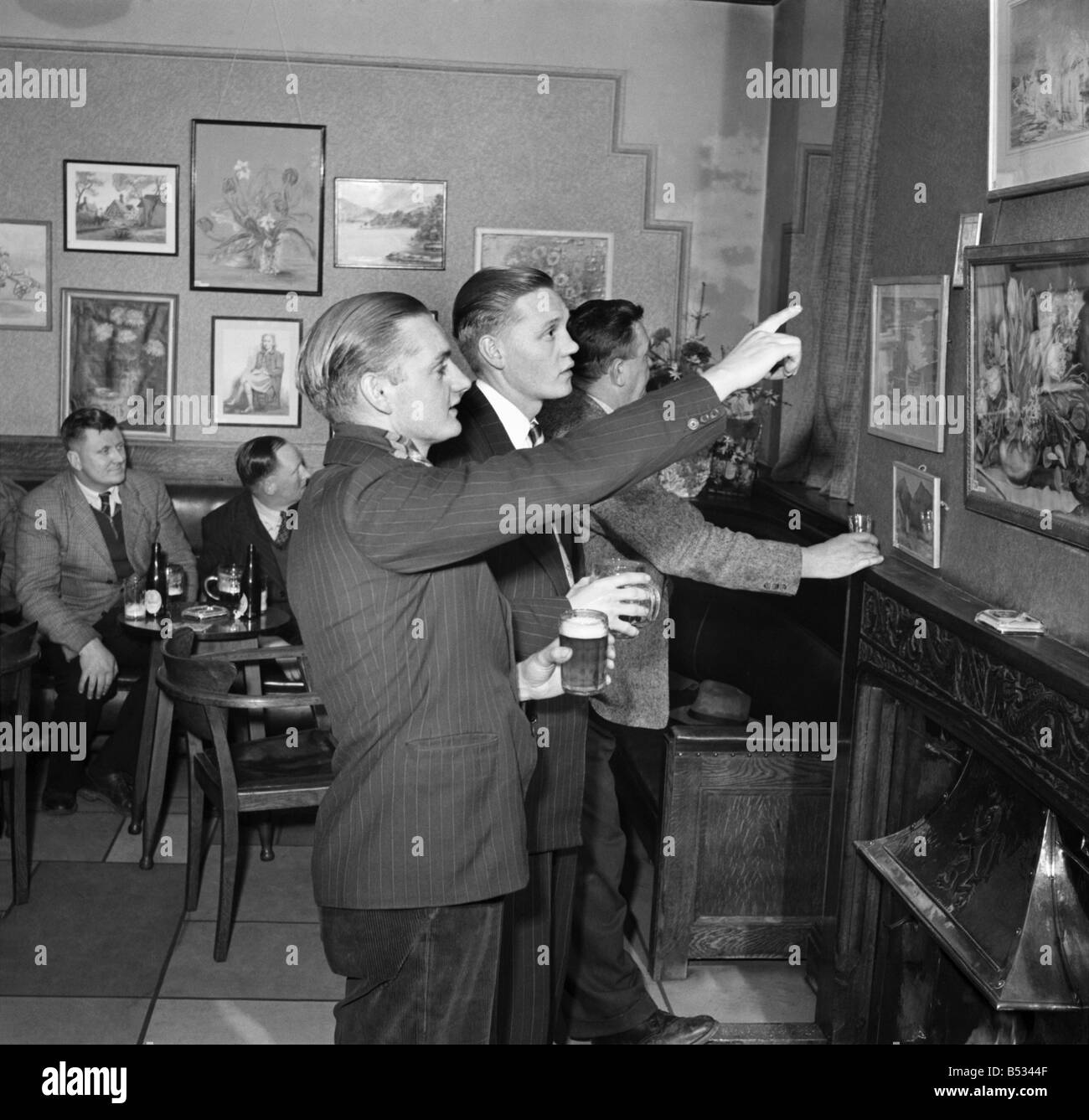 Norman Kenny of Sharston, Wythenshawe, discusses the finer points of art with some of the customers at the Airport Hotel, Ringway in Cheshire, whilst others, accustomed to the evening critics, carry on with their own particular discussion and pint. ;April 1952 ;C1330 Stock Photo