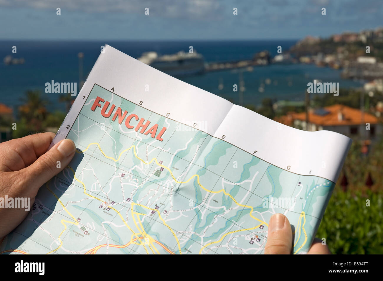 Close up of man looking at map with Funchal Harbour in background Madeira Portugal EU Europe Stock Photo