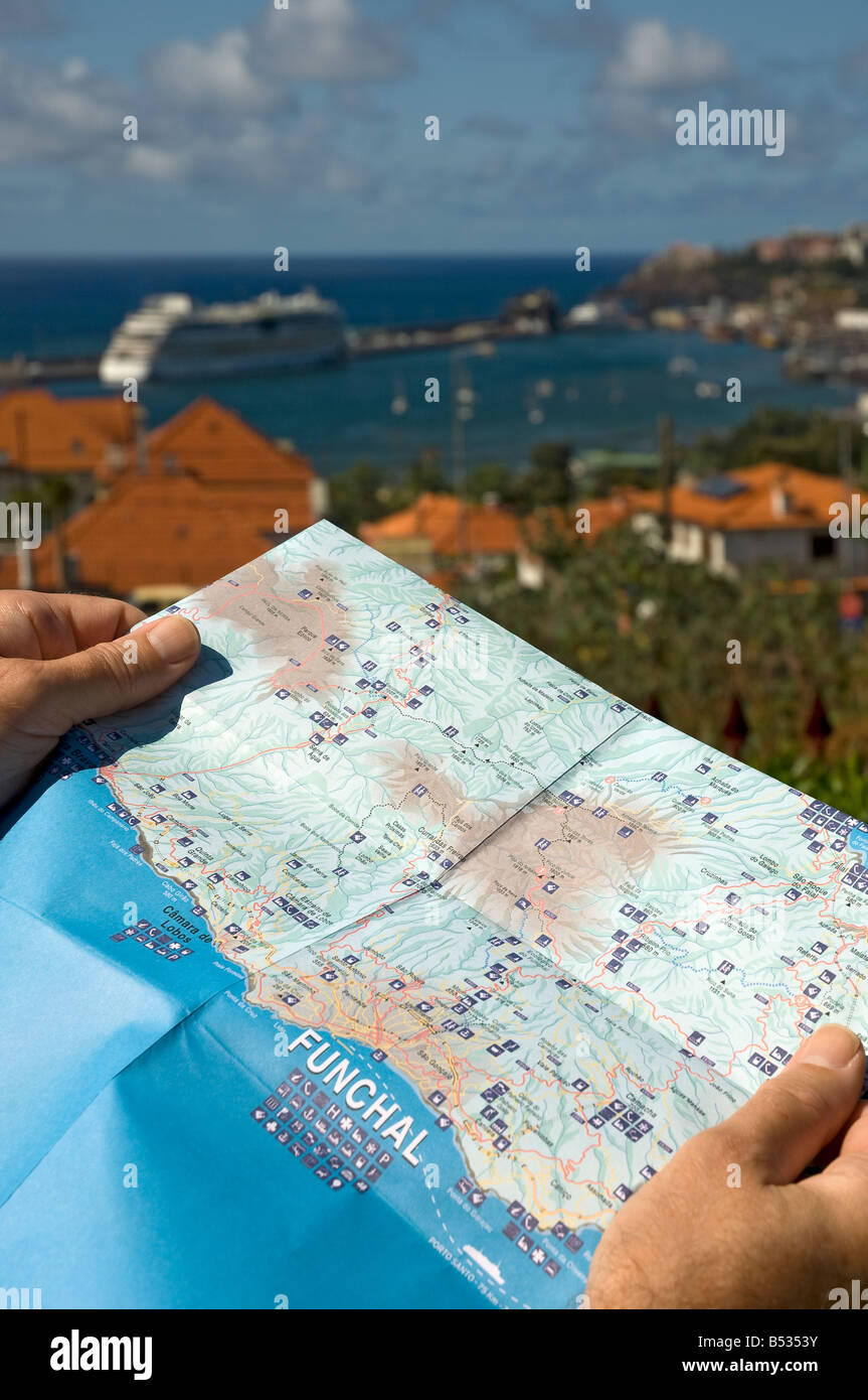 Close up of man holding map with Funchal Harbour in background Madeira Portugal EU Europe Stock Photo