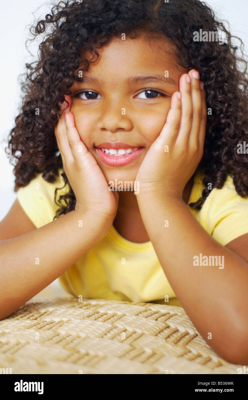 Close up of mixed race girl with head in hands Stock Photo