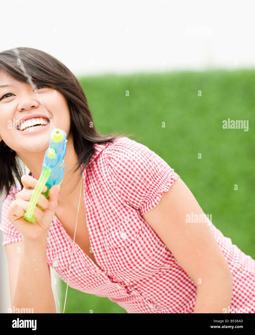 Asian woman squirting toy water gun Stock Photo - Alamy