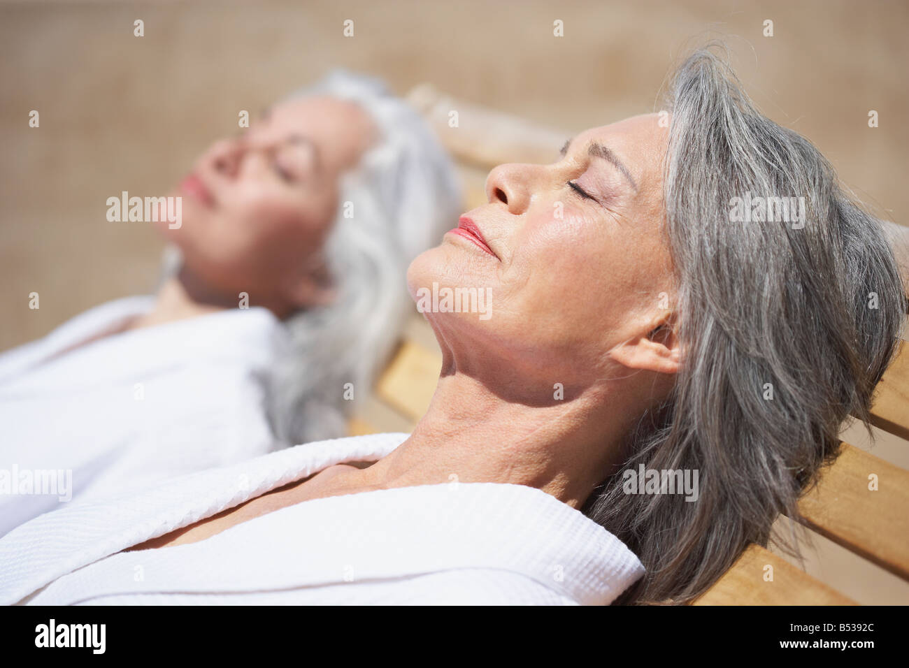 Friends sleeping on lounge chairs at resort Stock Photo Alamy