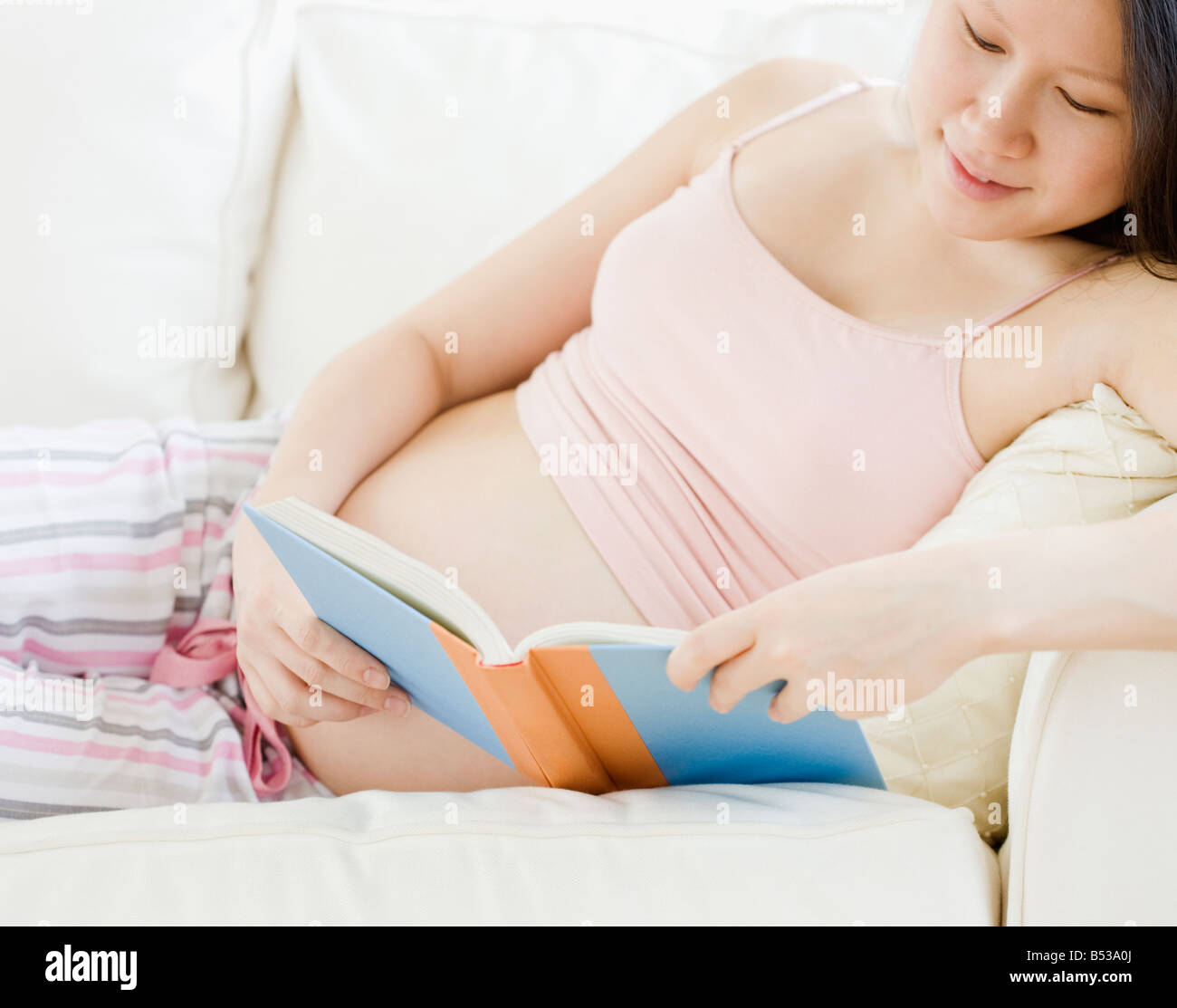 Pregnant Asian woman reading book Stock Photo