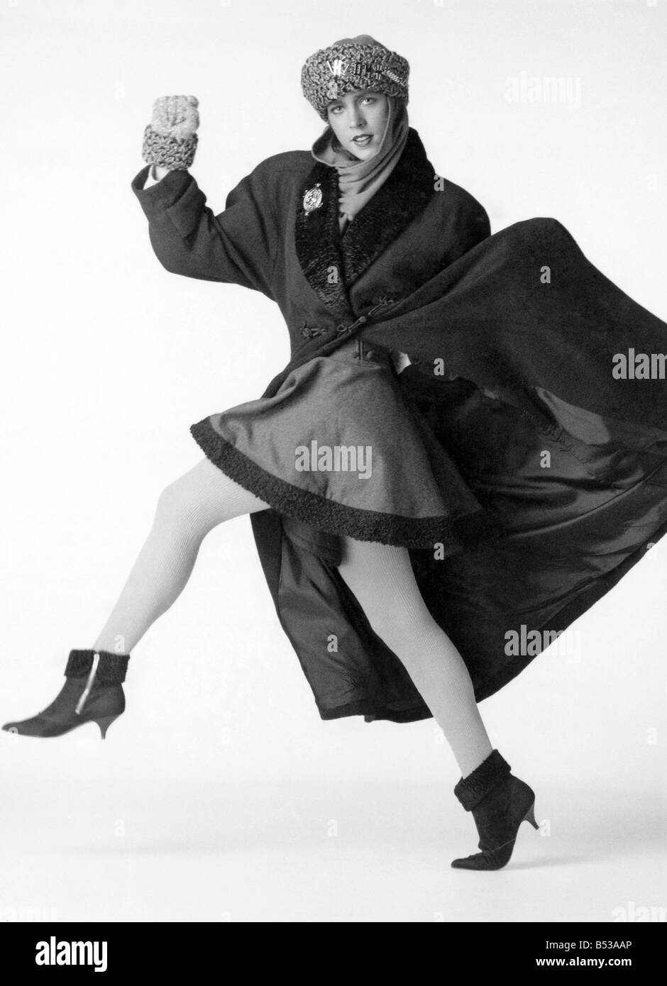 Fashion - Skirts. ;Fur trimmed long coat, Russian hat, fur trimed ankle boots and gloved.  Model skipping.;November 1987 P017859 Stock Photo