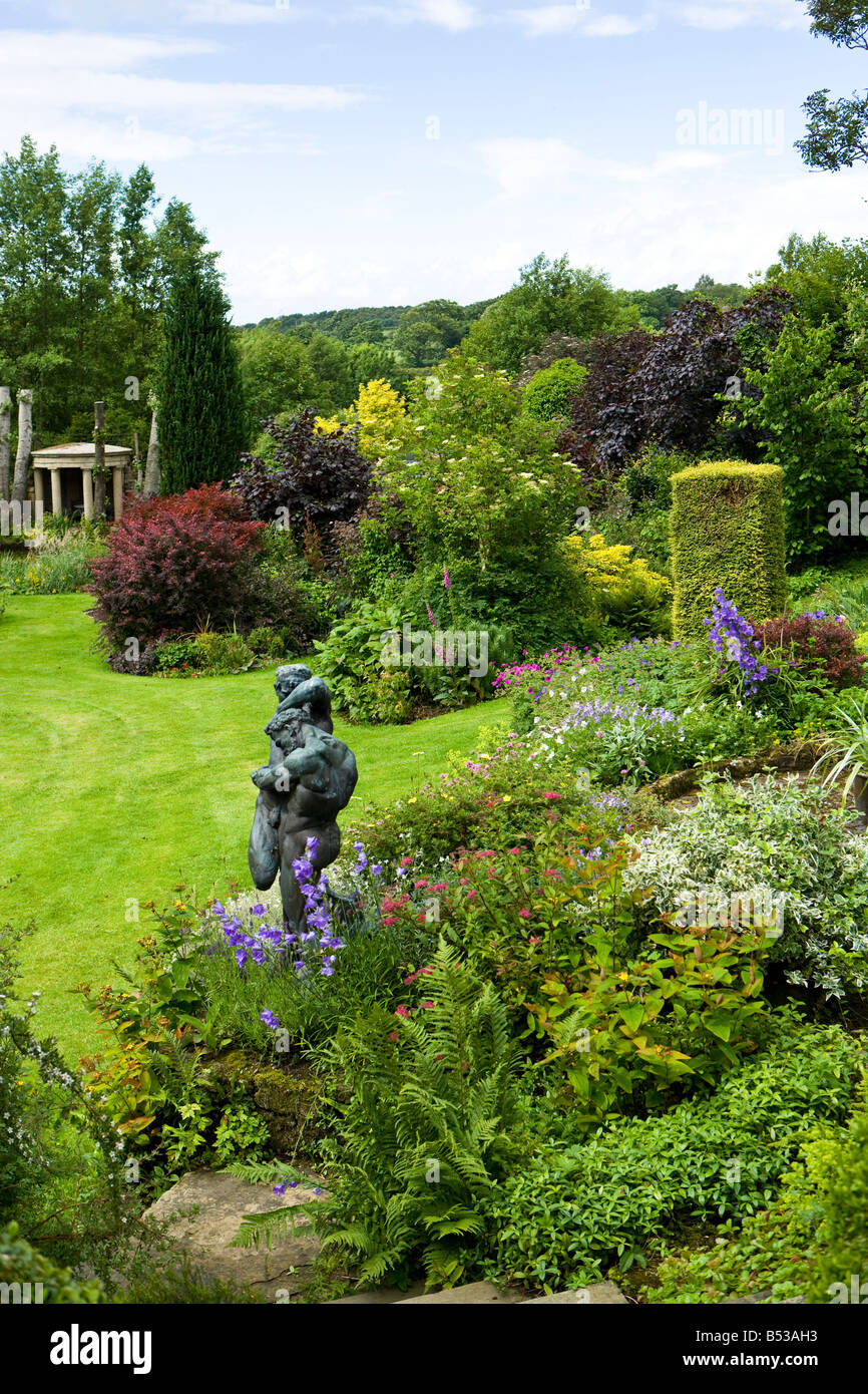 bronze statue in a well planted flower bed Stock Photo Alamy
