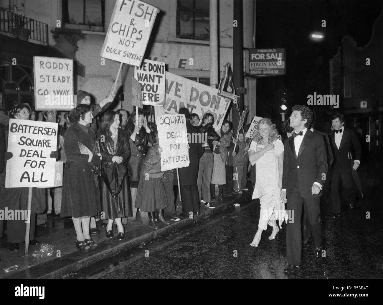 A couple arriving for the opening-night party of the new club belonging to Roddy Llewellyn, run the gaunlet of jeering domonstrators. ;April 1973 ;P018569 Stock Photo