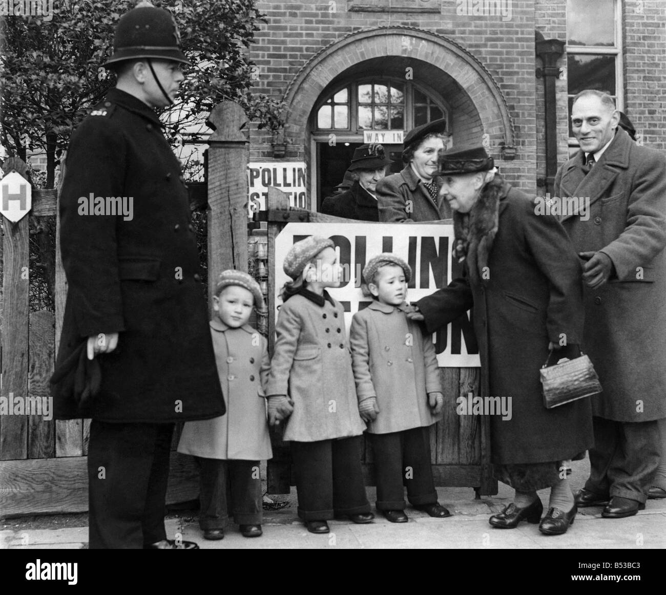 General Election 1950: The children of Mrs. Coreery, L to R. David, 3, June, 6, and Brenda 4, outside Roper Street Polling Booth. They were left in charge of a policeman. February 1950 P018683 Stock Photo