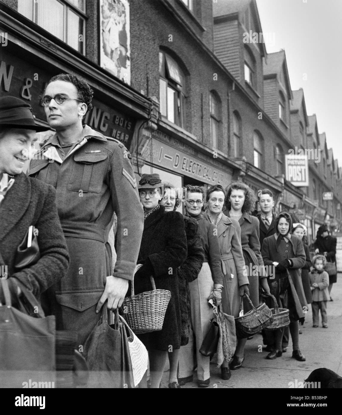 The corporal queues up on leave - It's just the same when you come on leave. Only it's not the Naafi, and it's not a mug of tea Stock Photo