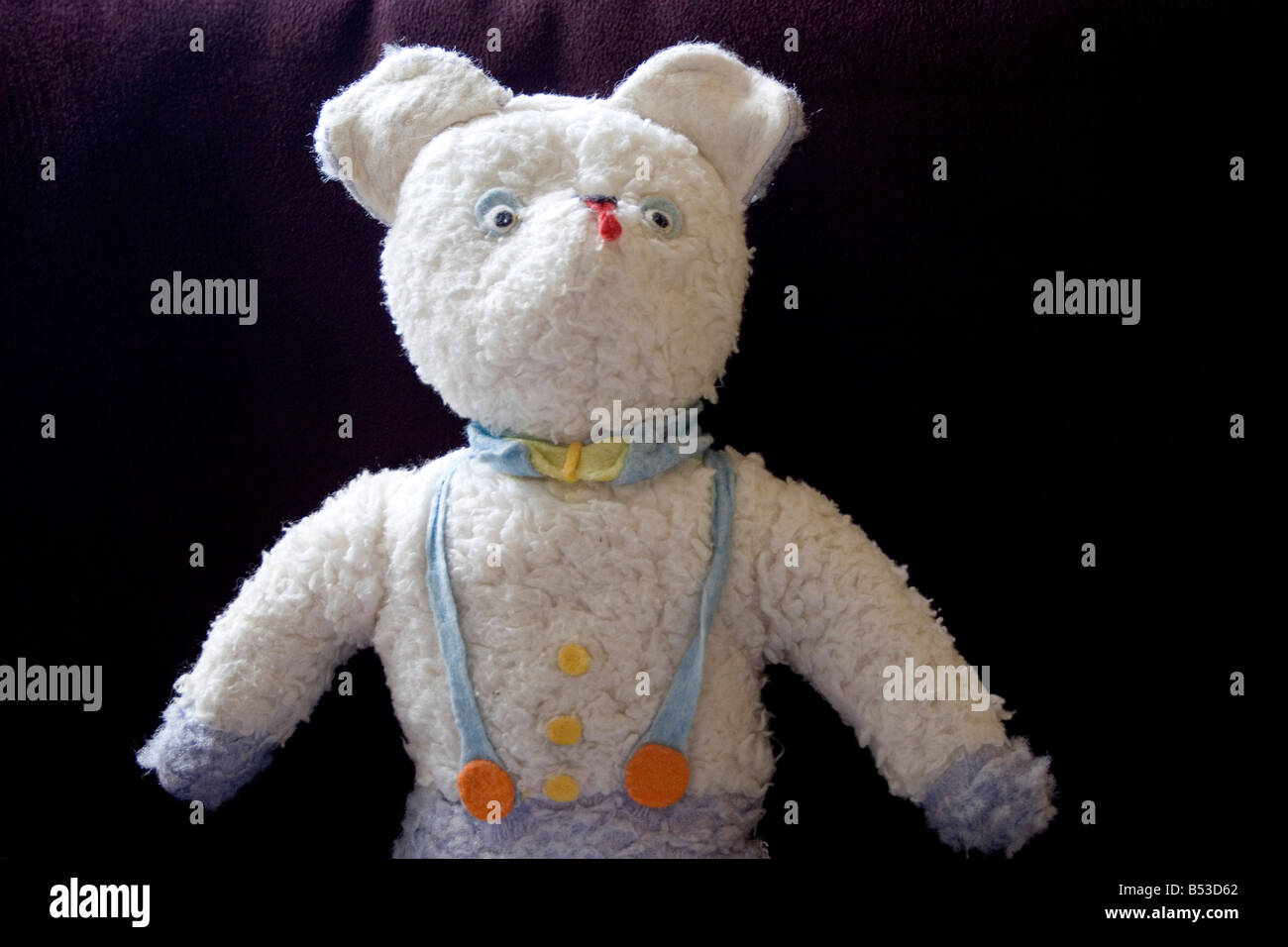 Close Up Of Old Stuffed Toy Sitting On Purple Chair Stock Photo