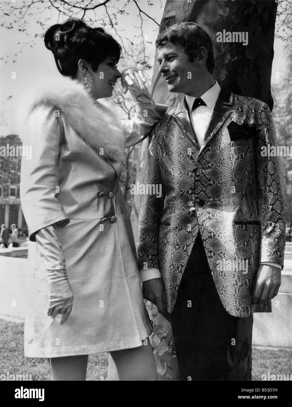 Fashion 1960's. On Monday (17-4-67) at the Europa Hotel, Grosvenor Square, the Leather Institute held its Annual leather fashion show. Thirteen models presented the new collection of 17 suede and leatherwear manufacturers. There were three fashion shows, for approximately 1,000 buyers from the UK and Overseas. Ralph Mutall wearing a python printed leather jacket and suede trousers by 'Newtone' and Nola Trolcar in a silver sheepskin coat and silver dress by John Homack. April 1967 P017557; Stock Photo