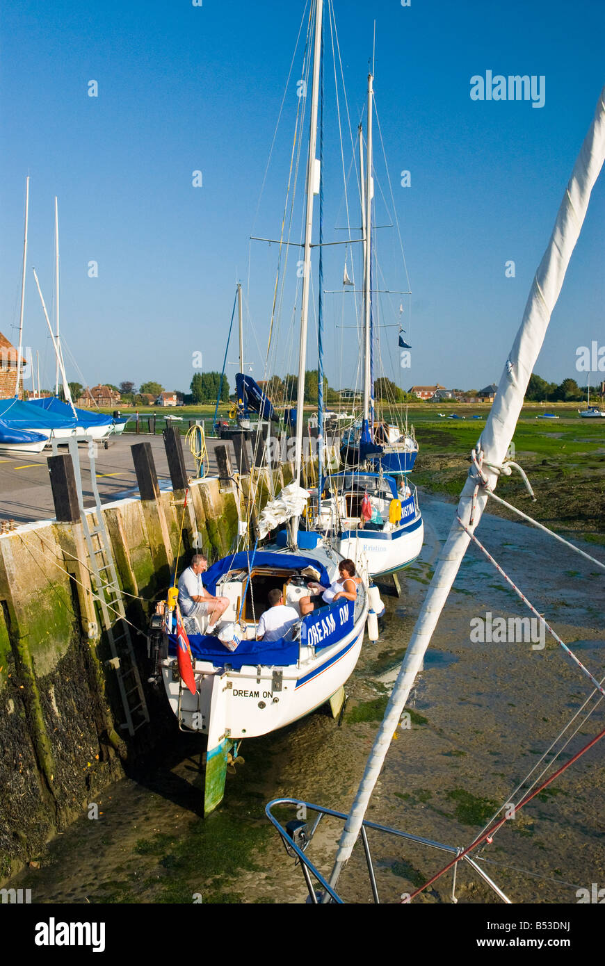 Bosham harbour quay side at low tide with yachts grounded Stock Photo
