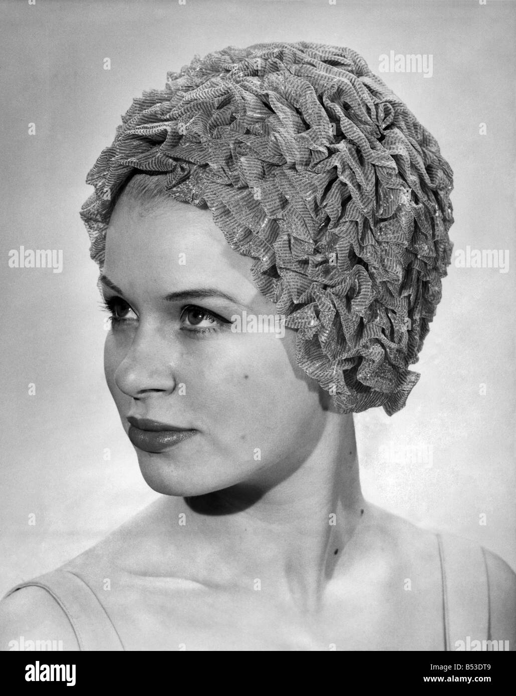 Clothing Beach: Frilly-Frilly layers of silver and gold, ruched and bunched closely together. Swimming hat. Humour. Price 39s. 6d. June 1965 P018018 Stock Photo