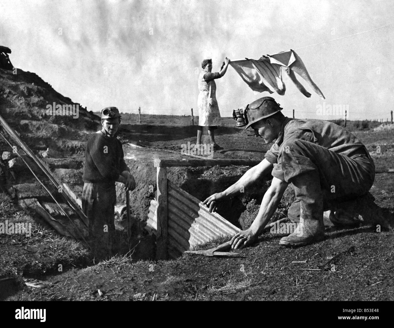 Men working in a coal mine at the bottom of the garden as his wife