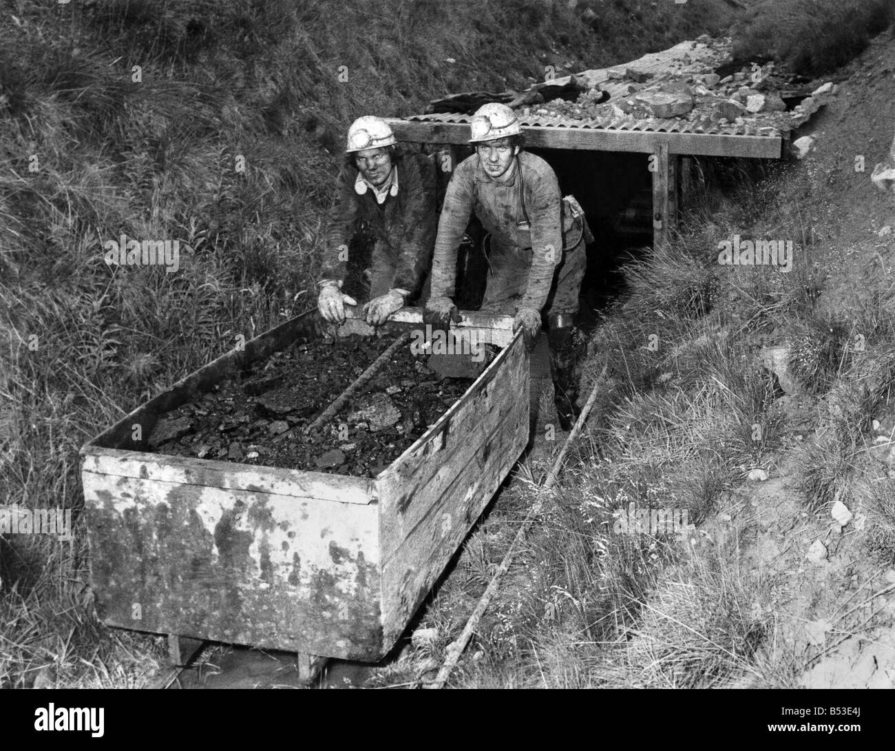 Two men pushing a cart full of coal  in a mine. &#13;&#10;July 1978 &#13;&#10;P018160 Stock Photo