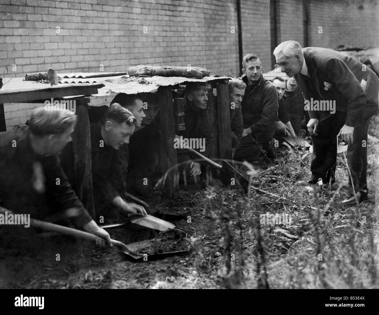 Pit props held up a corrugated iron roof about two feet from the ground, to give the impression of the general depth of the coal seams in the North-East, and the men with pick and shovel hew and fill, using the earth as 'make-believe' coal. September 1946 P018167 Stock Photo