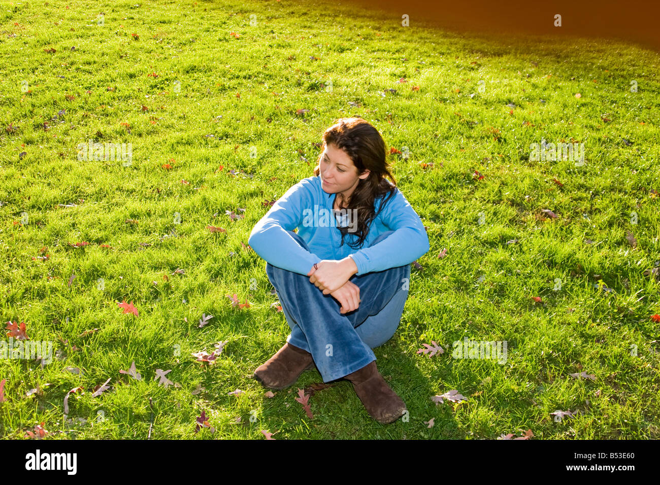 Young woman sitting on the grass at a park Model Released Stock Photo ...