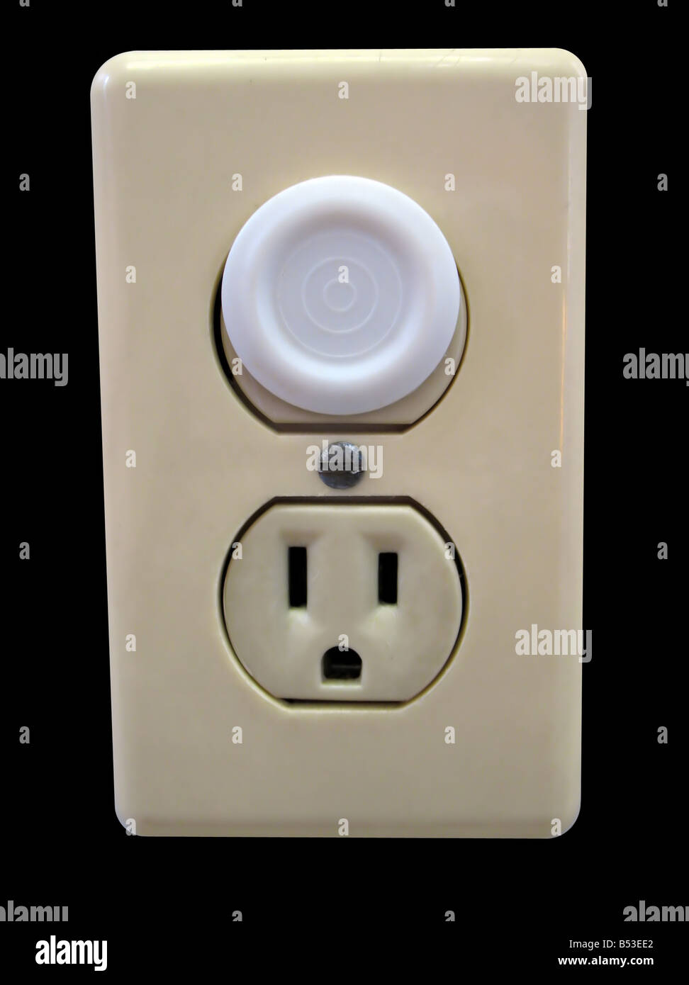 an electrical outlet complete with child safety plug isolated over black Stock Photo