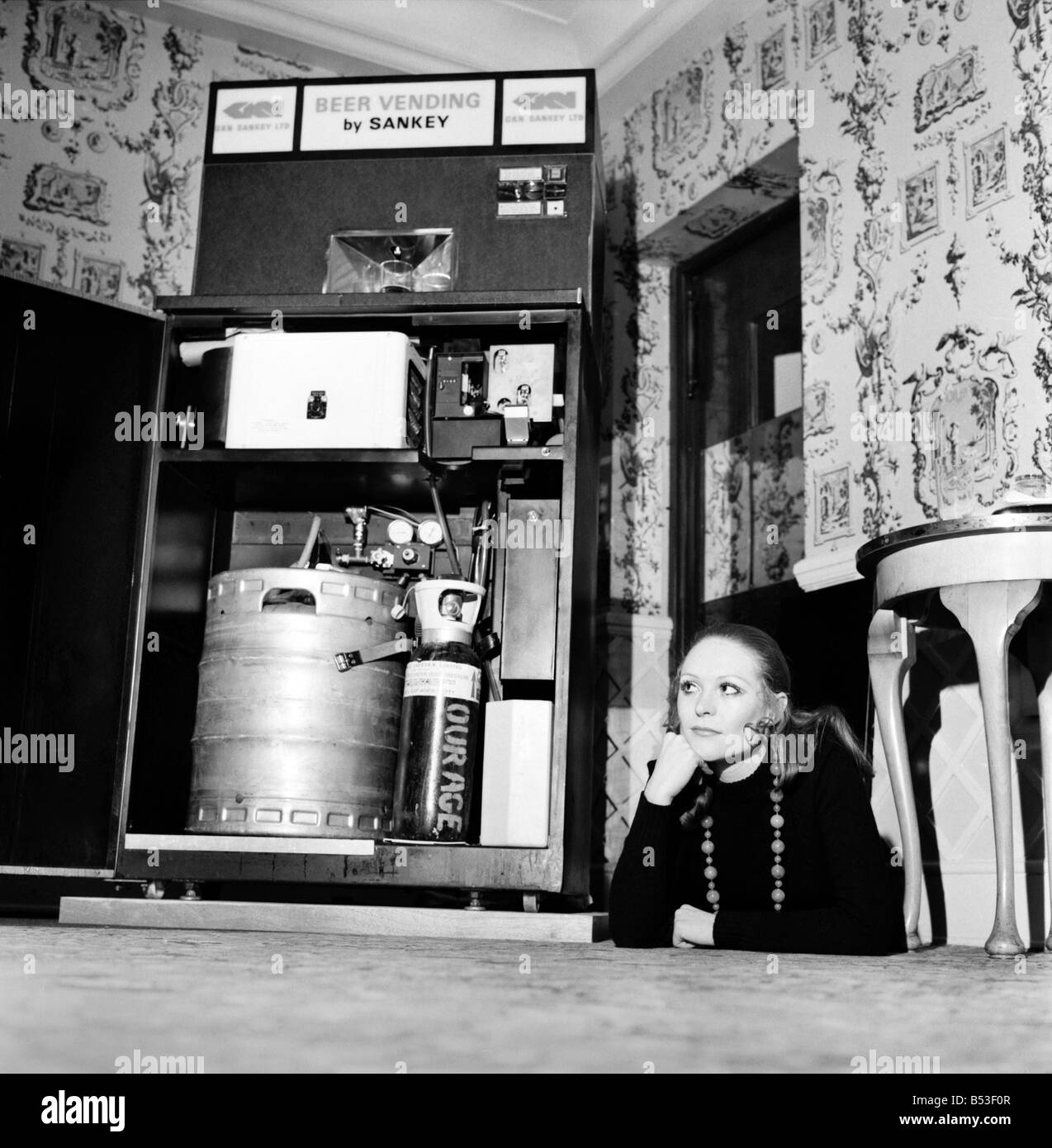Inventions: Britain's first automatic refrigerated draught beer vending machine was demonstrated by the Brewery Division of GKN Sankey Ltd., of Bilston Staffs, at Quaglino's Bury Street, London. Woman with the front of the autobarmaid open showing the interior. December 1969 Z11595-001 Stock Photo