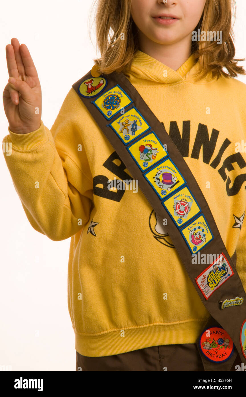 repose brain delicate 10 year old girl dressed in Brownies uniform showing her collection of  merit badges for completing tasks and acquiring skills Stock Photo - Alamy