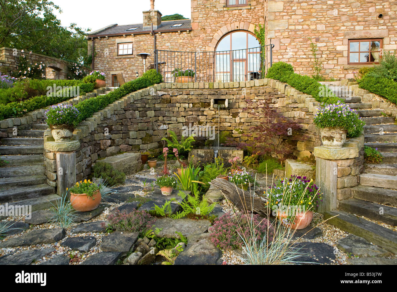 ferns and sedums growing in a large rockery Stock Photo - Alamy