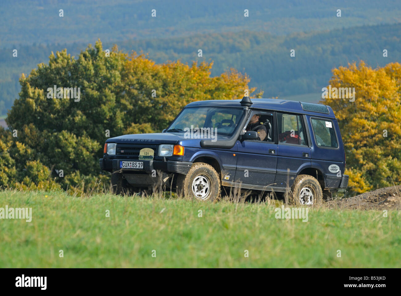 1990s Land Rover Discovery 1, fitted with a raised air intake, on a forest track in the hilly Weserbergland. Stock Photo