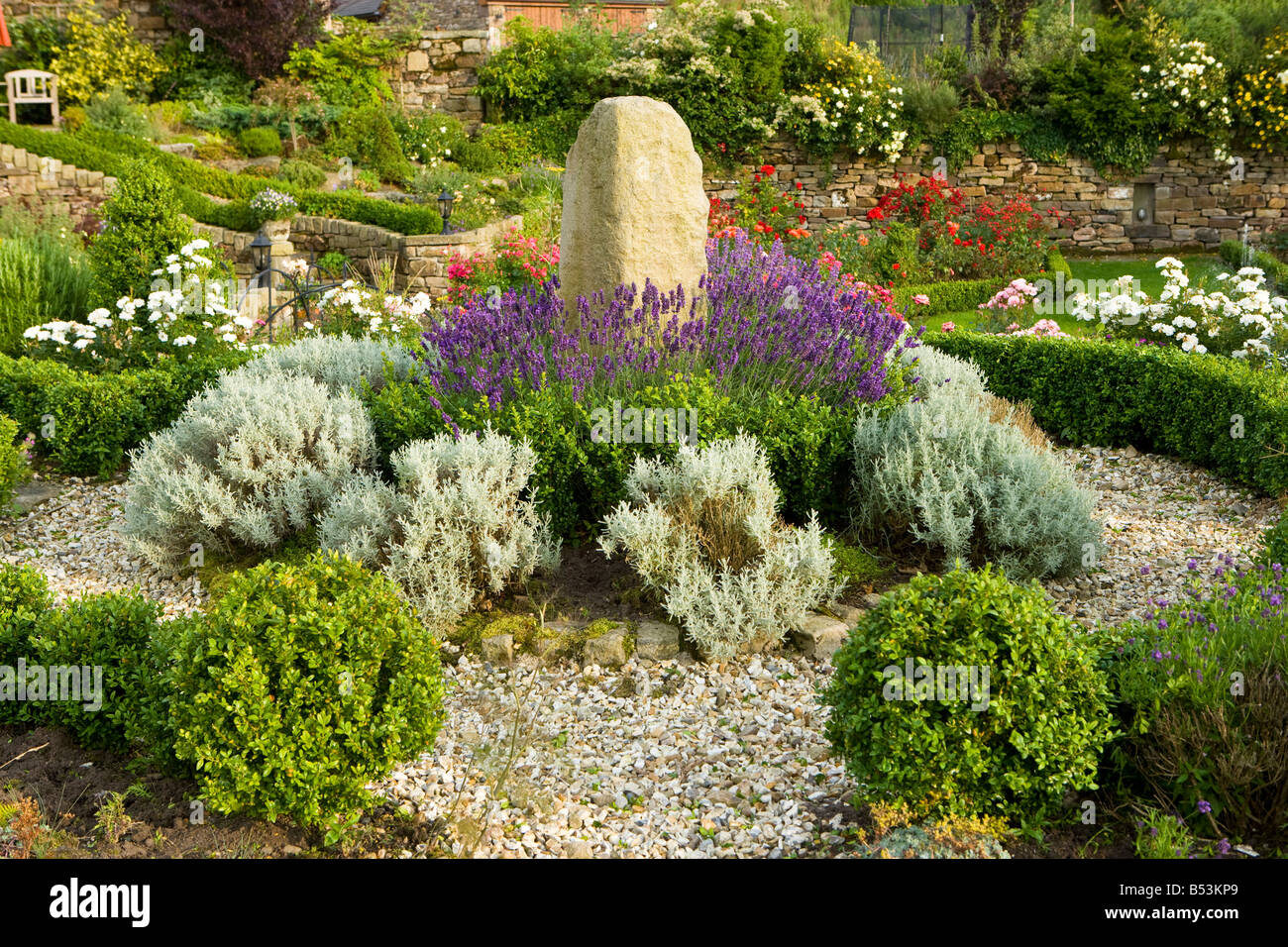 standing stone garden feature with extensive planting Stock Photo Alamy