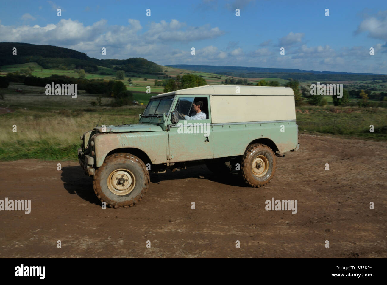 Muddy light green 1970s Land Rover Series 3 LWB Hardtop on a forest track in the Weserbergland. Stock Photo