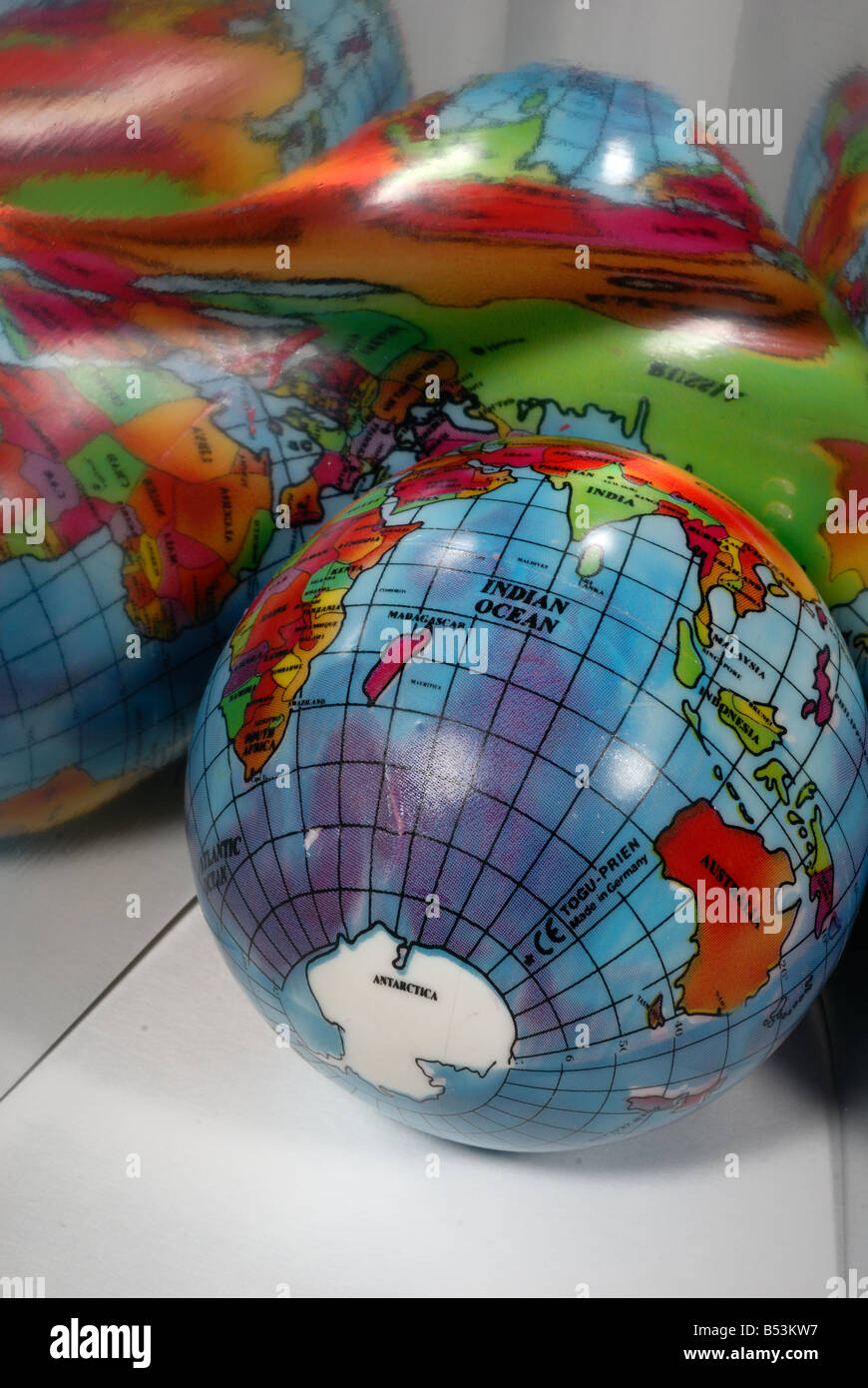 A world globe is reflected on a shiny surface Stock Photo