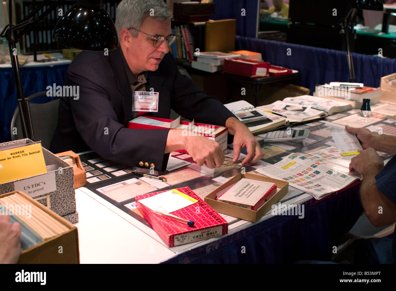 Stamp dealer offers stamps for sale at a booth at the American Philatelic Society stamp show in Hartford Connecticut Stock Photo